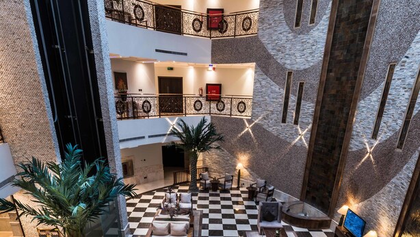 A lobby with a checkered floor, multiple seating areas, and a staircase. - Boudl Al Fakhria (Unaizah)