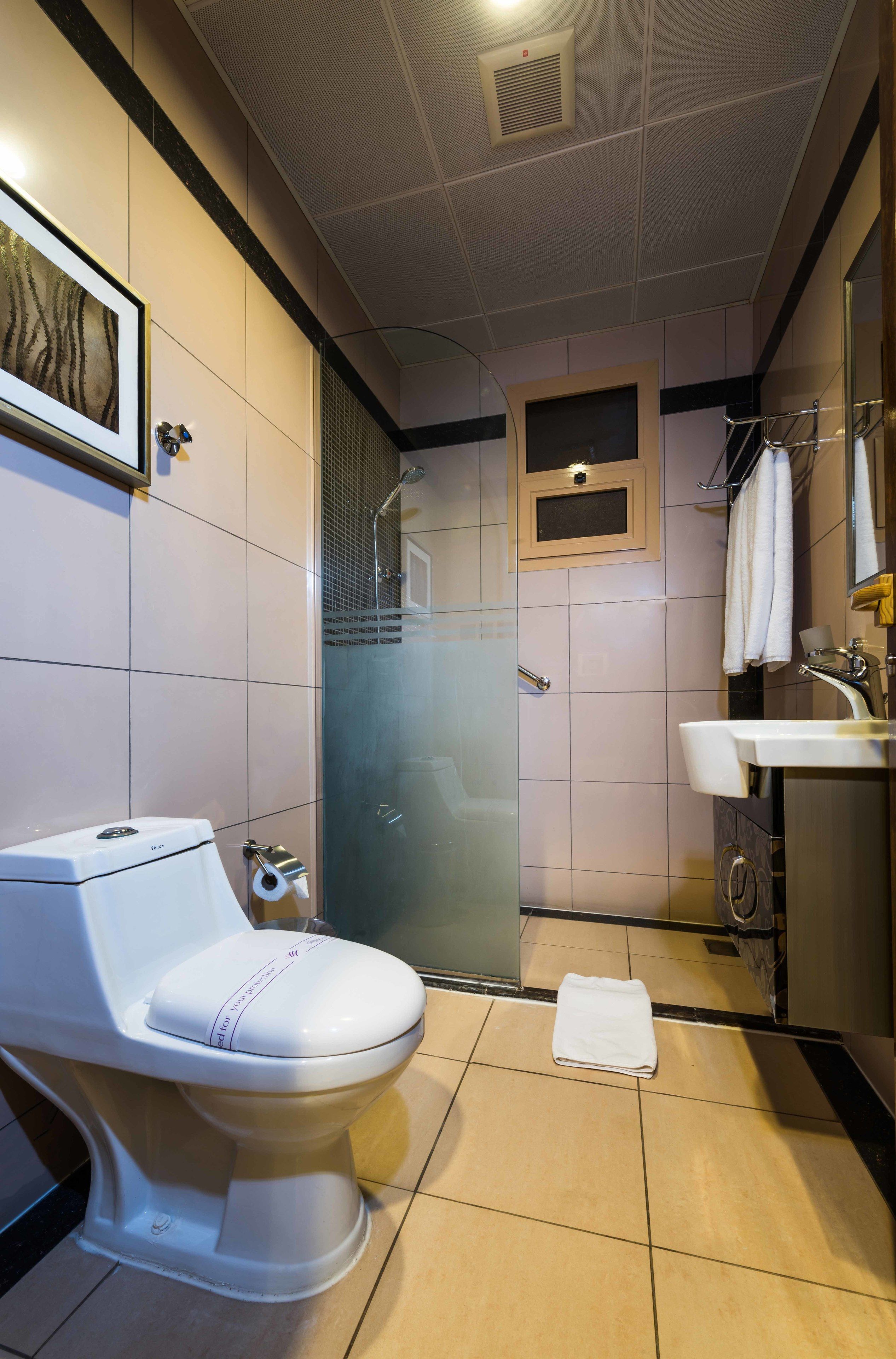 Un baño moderno con inodoro, ducha y lavamanos.