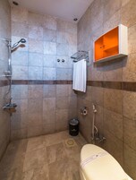 Un baño con ducha, inodoro y toallero.