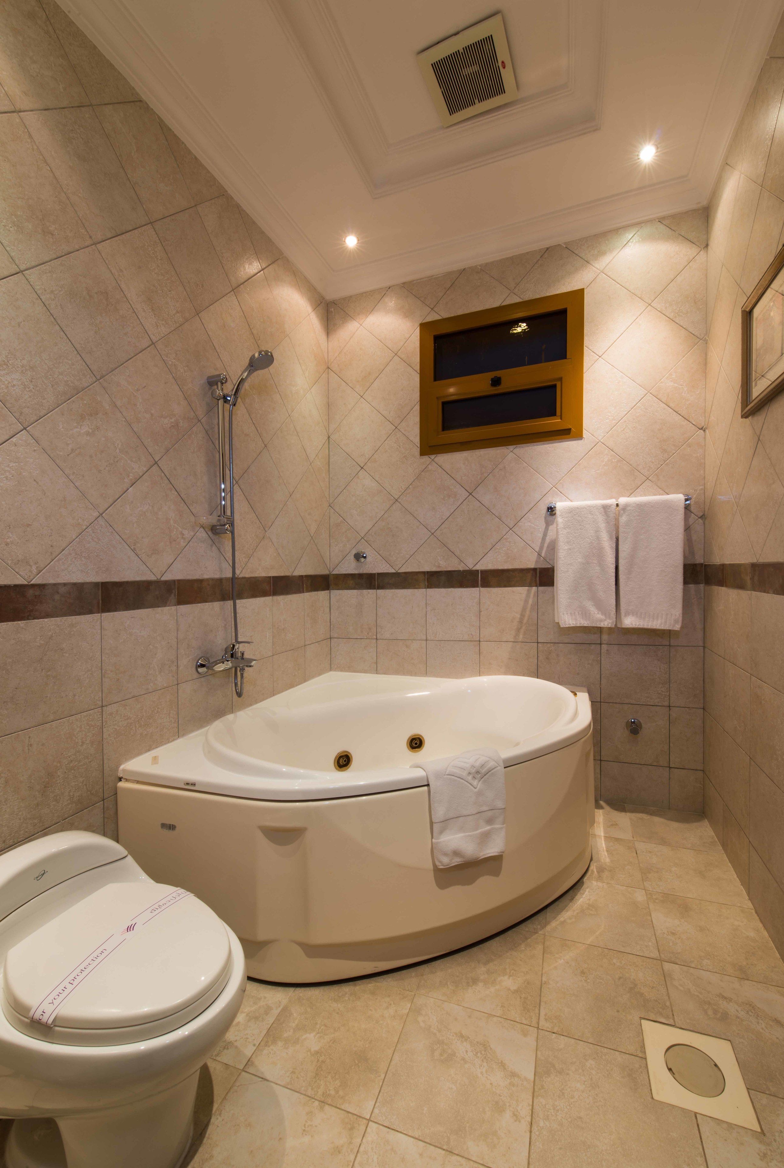 A bathroom with a freestanding bathtub, a toilet, and a shower.
