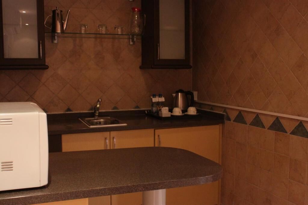 A kitchen with a built-in oven, a sink, and a countertop.