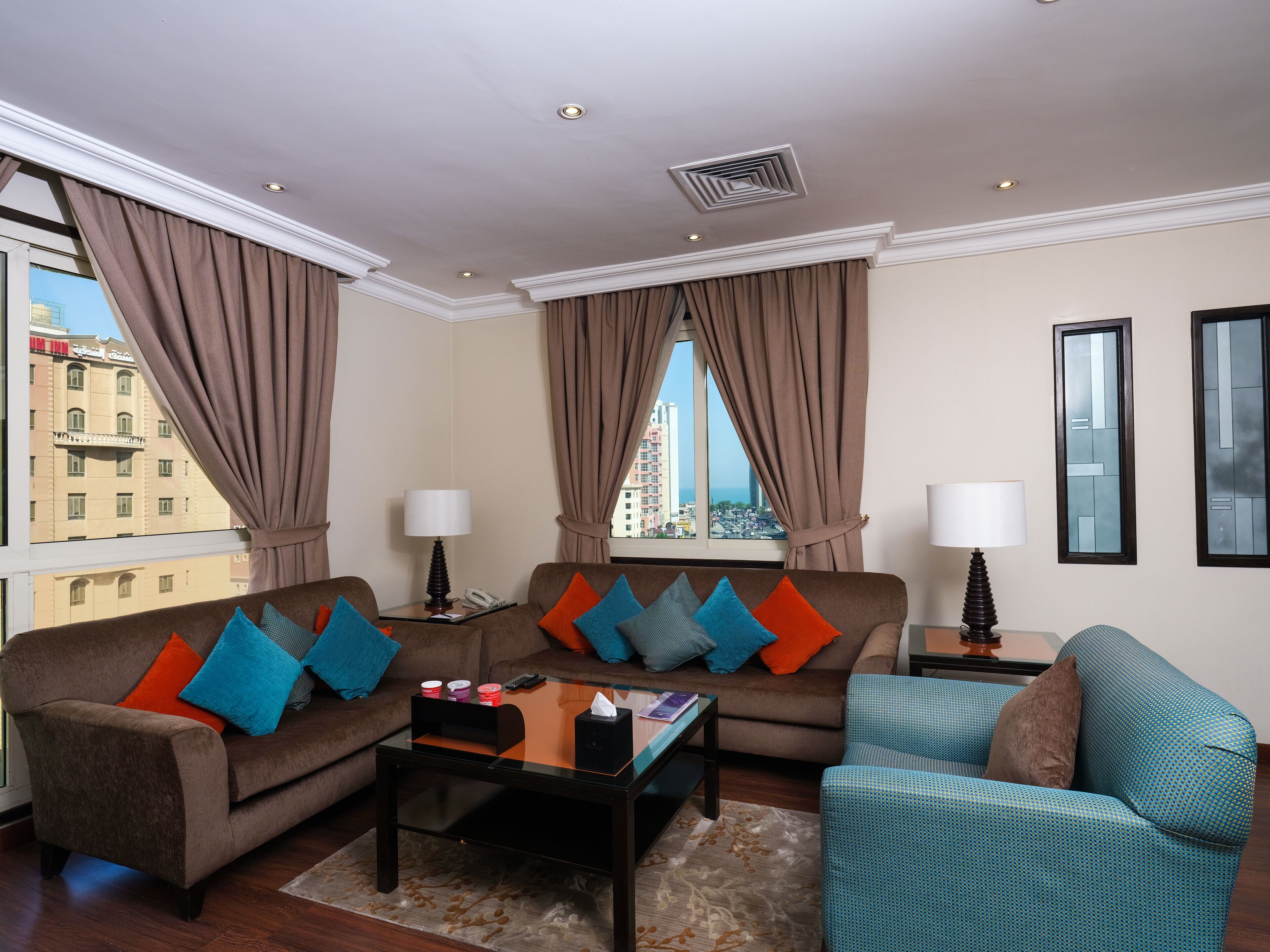 A modern living room with two sofas, a coffee table, and a side table with lamps.