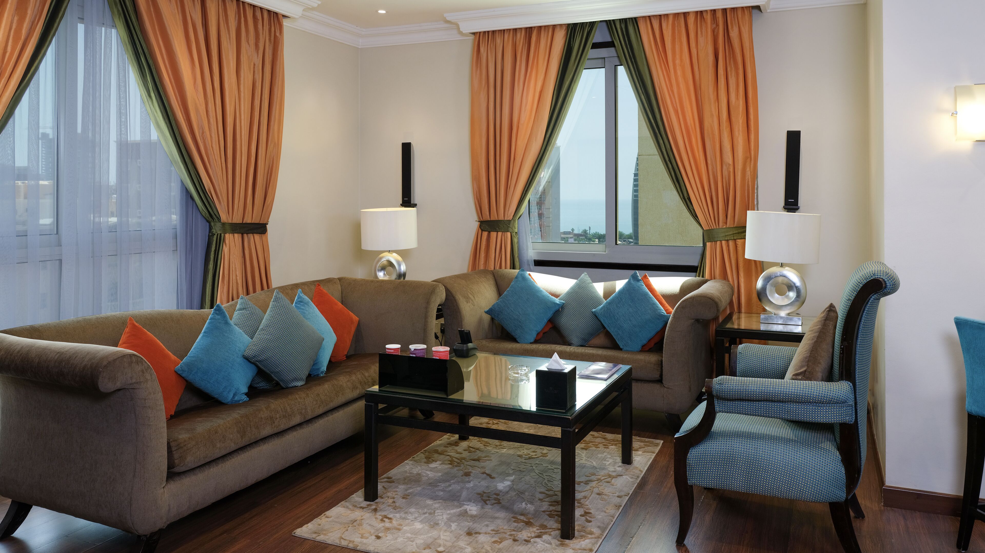 A living room with a sofa, armchairs, a coffee table, and a rug.
