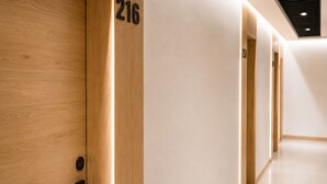 Un couloir avec des portes en bois, chacune portant un numéro.
