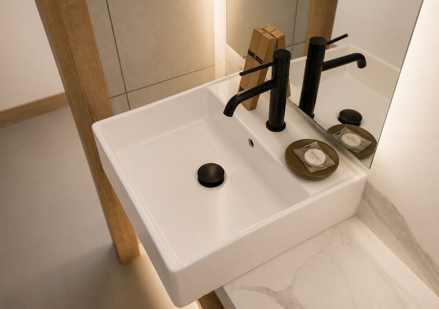 Un baño con un lavamanos blanco, grifo negro y un espejo.
