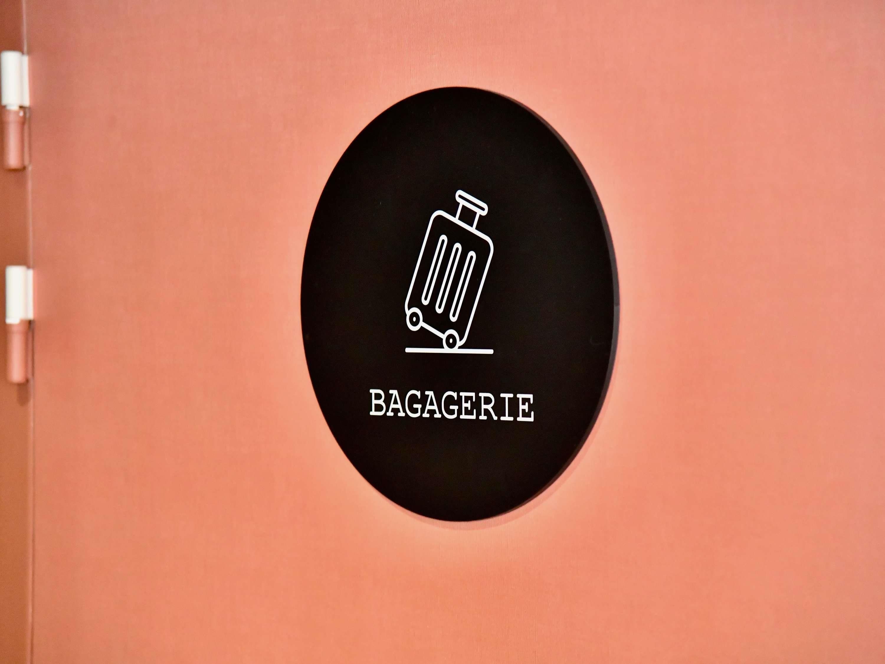 A circular sign with a trash bin icon and the word "BAGAGERIE" on a peach-colored background.
