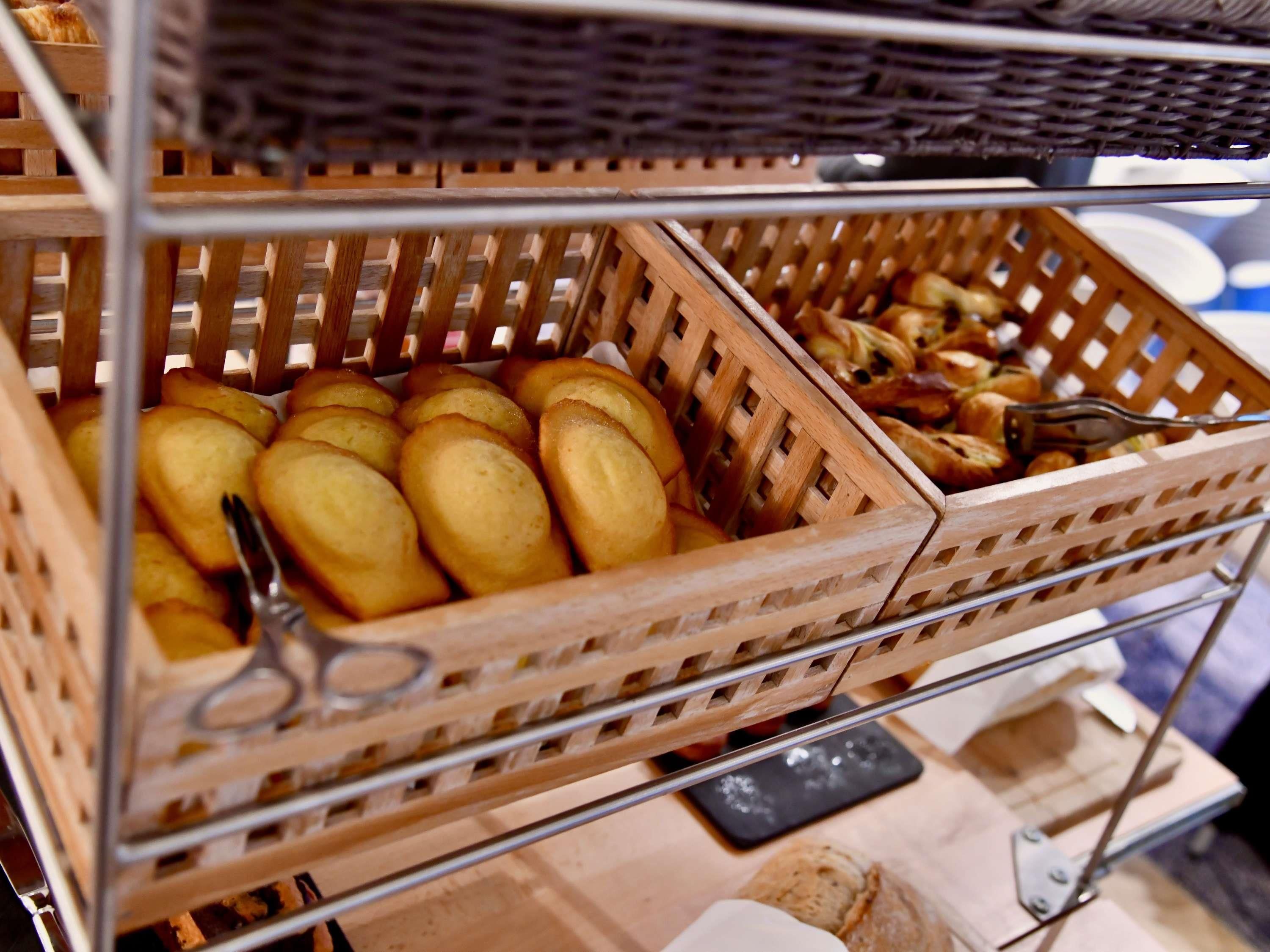 Wicker baskets with baked goods on a metal rack.