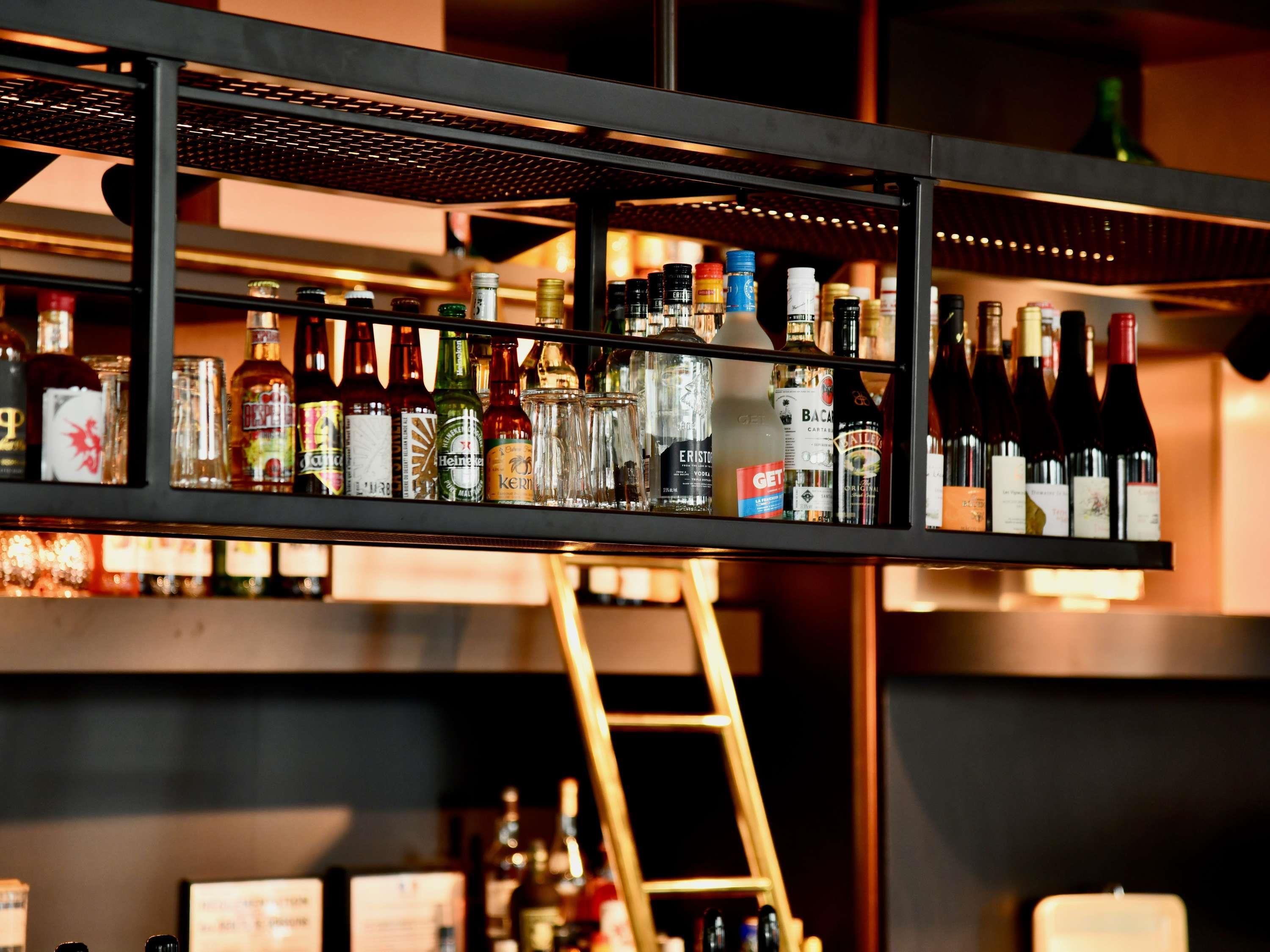 Un bar con estanterías llenas de diversas botellas de licores, incluyendo vino y destilados.