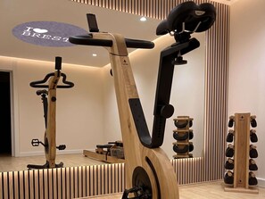 A stationary bike, a wall-mounted rack, and a shoe rack in a room with a modern design. - ibis Styles Brest Centre Port (Brest)