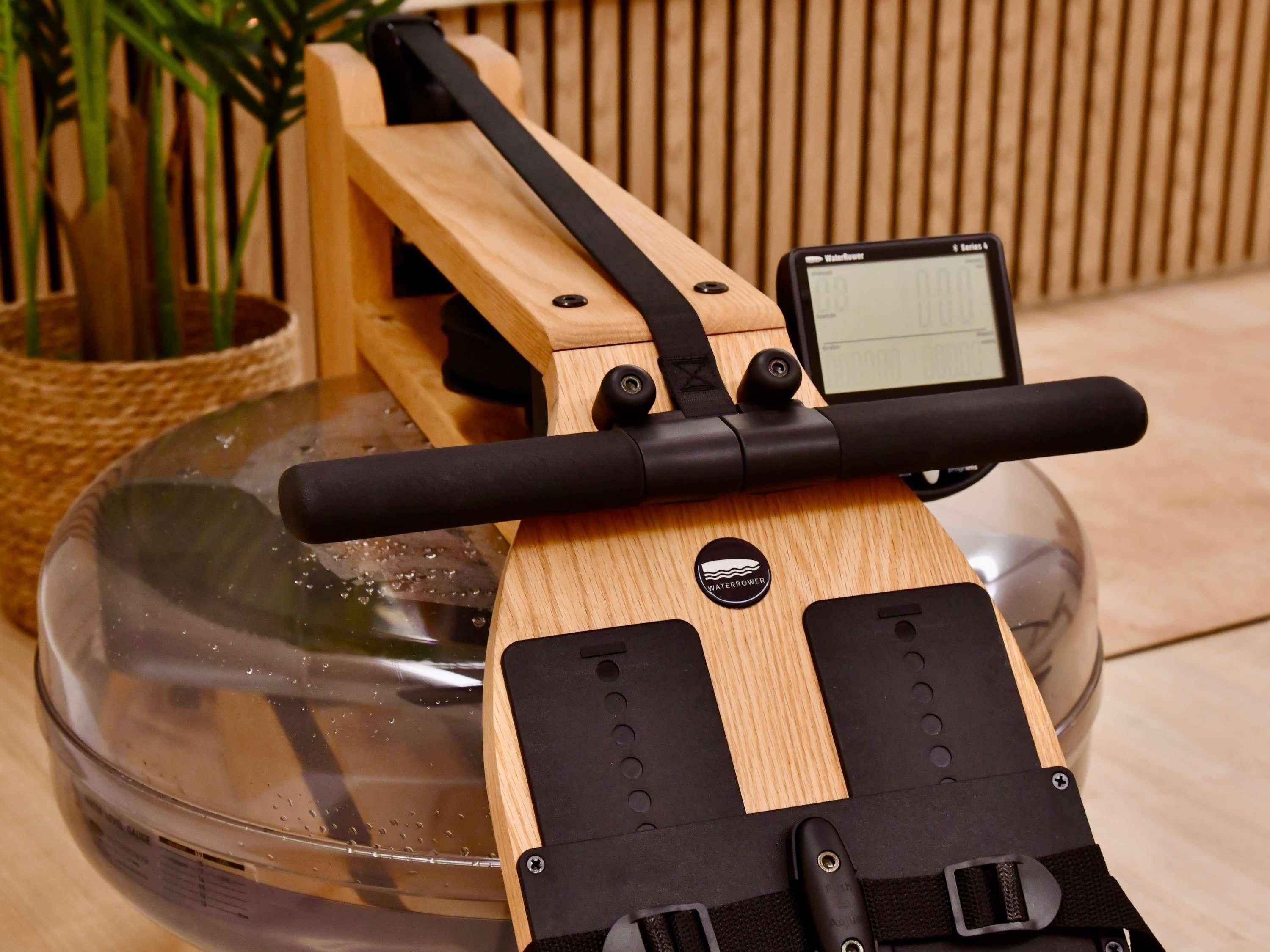 Una caminadora acuática con pantalla digital, estructura de madera y correas negras.