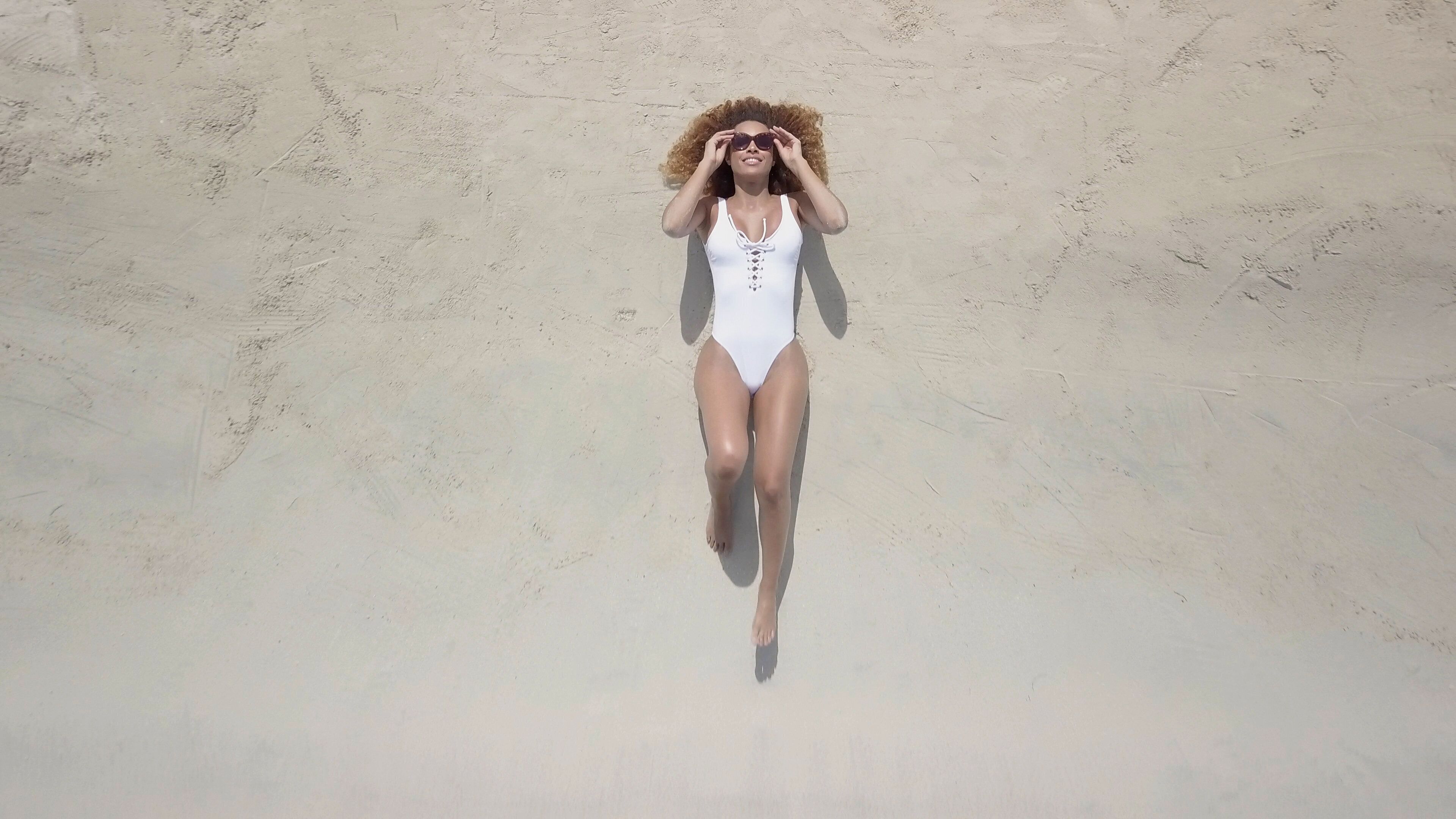 A person lying on a sandy surface.