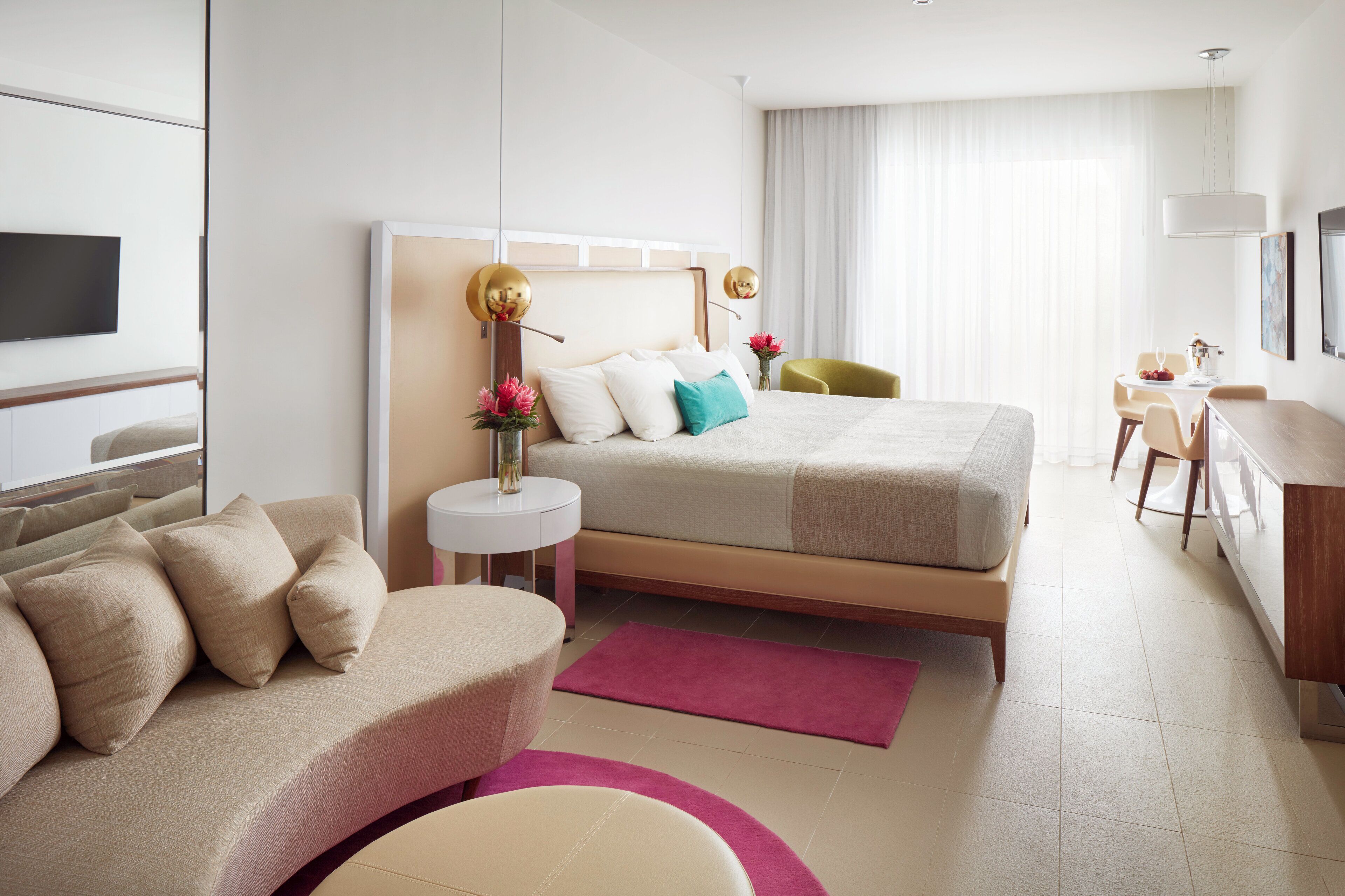Une chambre d’hôtel moderne équipée d’un lit, d’un bureau, d’une chaise et d’un téléviseur.
