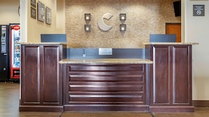 A reception area with a stone wall, a clock, and a Coca-Cola vending machine. - Comfort Inn & Suites Lakeside (Eagle Pass)