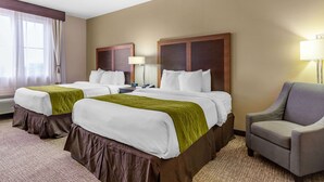 A hotel room with two beds, a chair, a lamp, and a window with curtains. - Comfort Inn & Suites Lakeside (Eagle Pass)