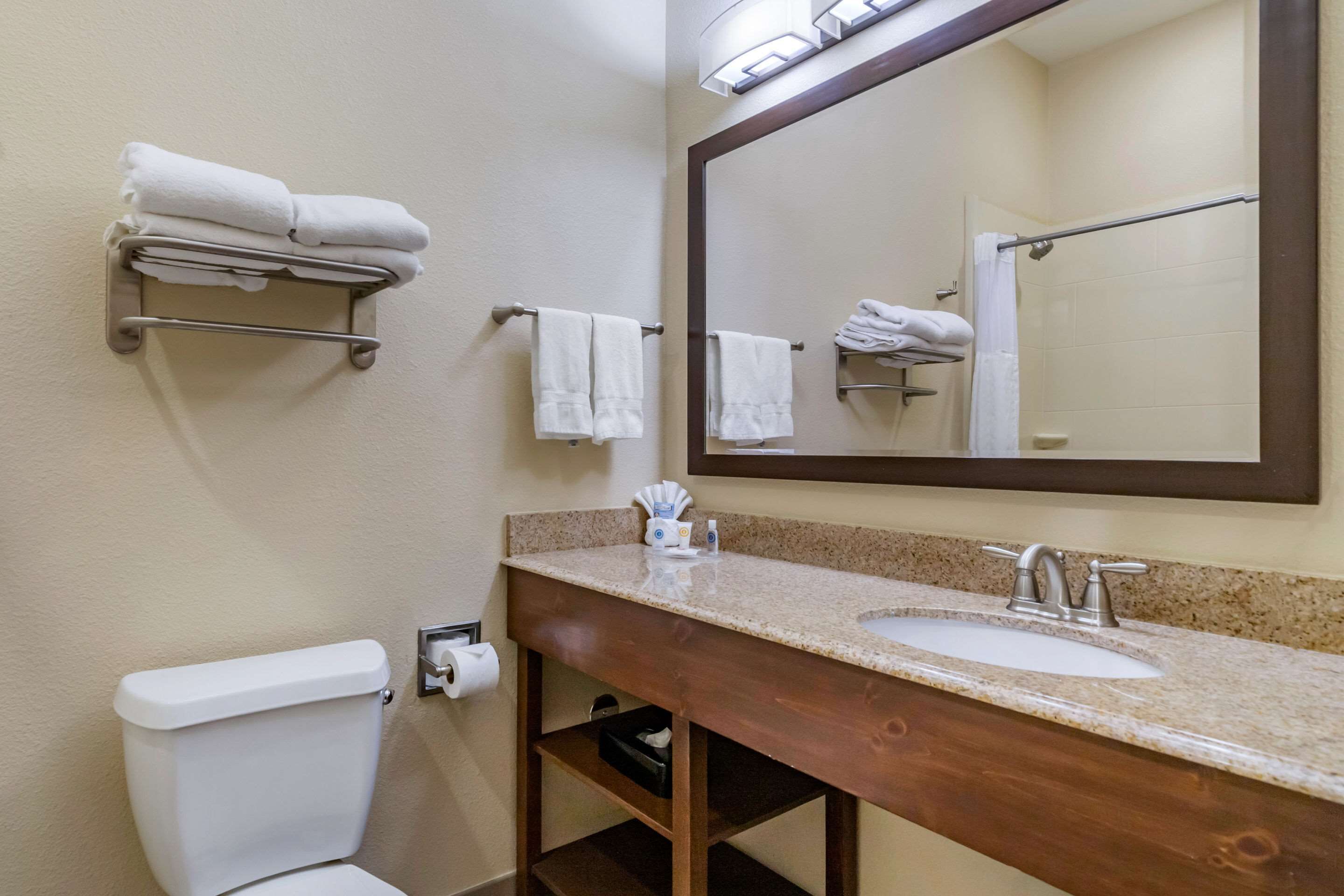 Un baño con inodoro, lavamanos y perchero para toallas.