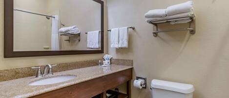 A bathroom with a sink, mirror, towel rack, and toilet.