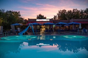 Piscine extérieure en saison, parasols, chaises longues