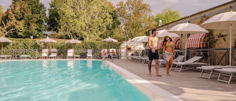 Een seizoensgebonden buitenzwembad en parasols bij het zwembad