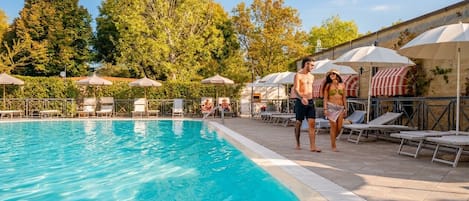 Piscine extérieure en saison, parasols, chaises longues