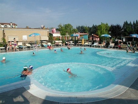Una piscina al aire libre de temporada, sombrillas