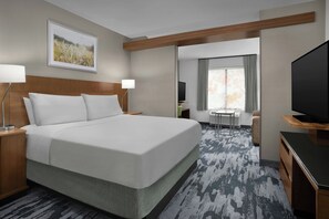 A modern hotel room with a large bed, bedside lamps, a flat-screen TV, a desk with a chair, and a window with curtains. - Fairfield Inn & Suites Jeffersonville I-71 (Jeffersonville)