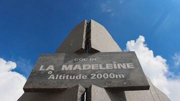 A monument with 'COL DE LA MADELEINE Altitude 2000m' inscribed.