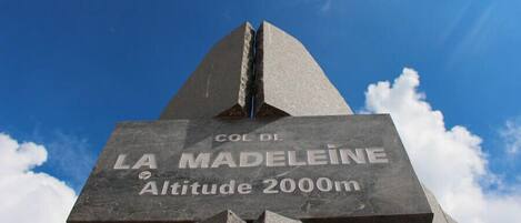 A monument with 'COL DE LA MADELEINE Altitude 2000m' inscribed.