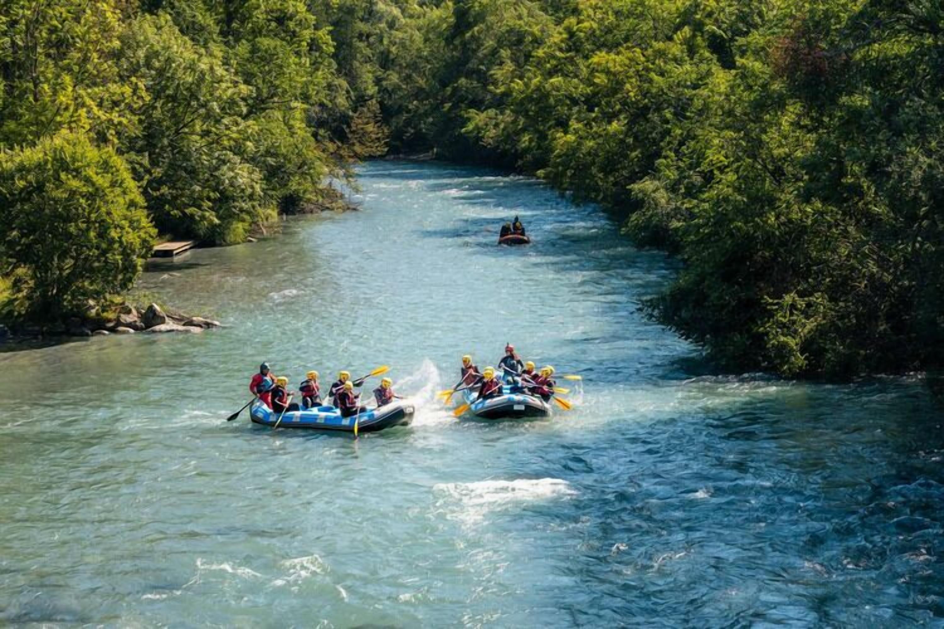 A river with two groups of people rafting.