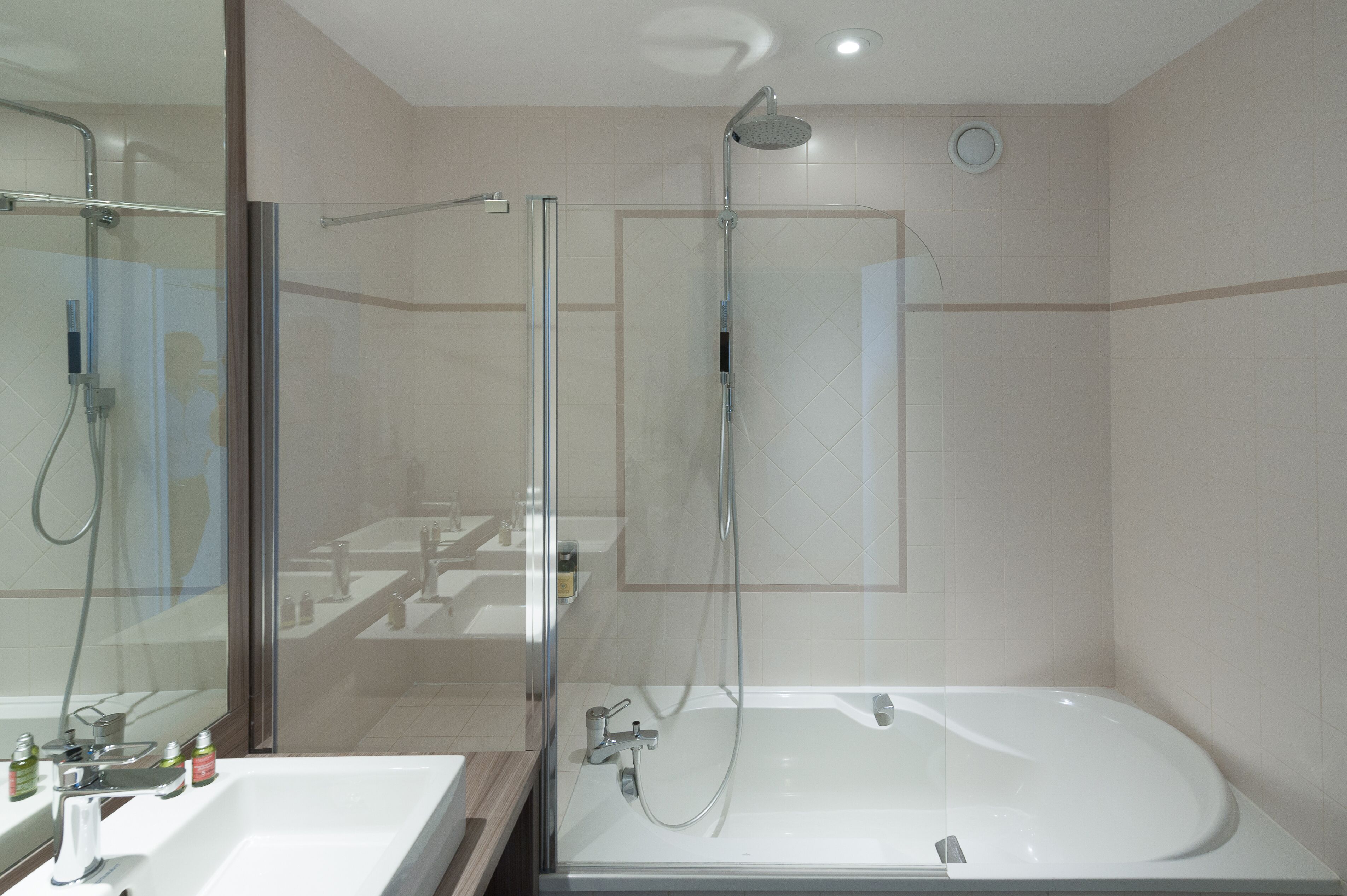 Un baño moderno con ducha de vidrio, una bañera independiente y un espejo grande.
