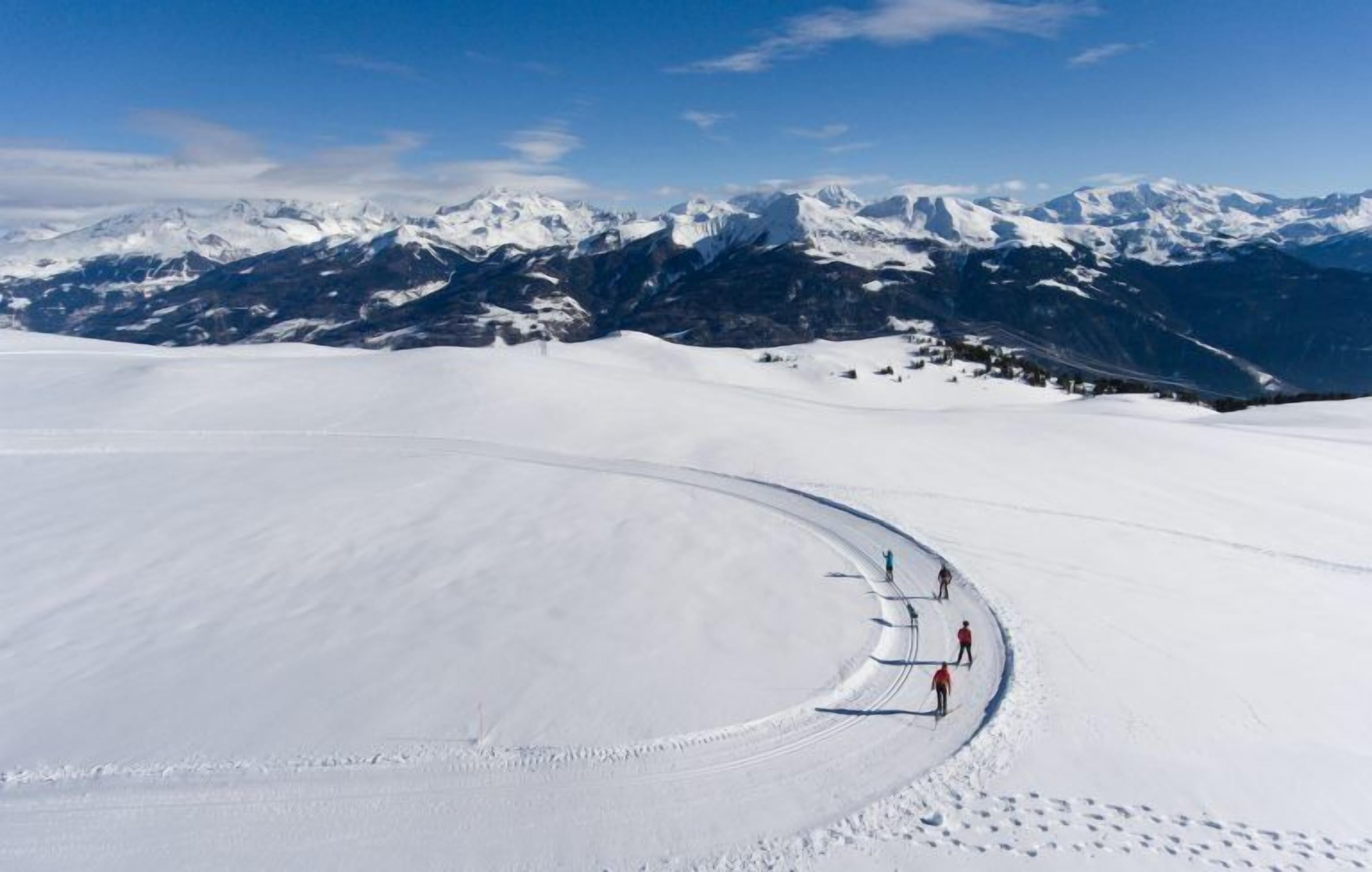 A snow-covered landscape with a clear sky and distant mountains.