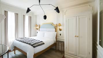A spacious bedroom with a large bed, a wardrobe, and a chandelier.