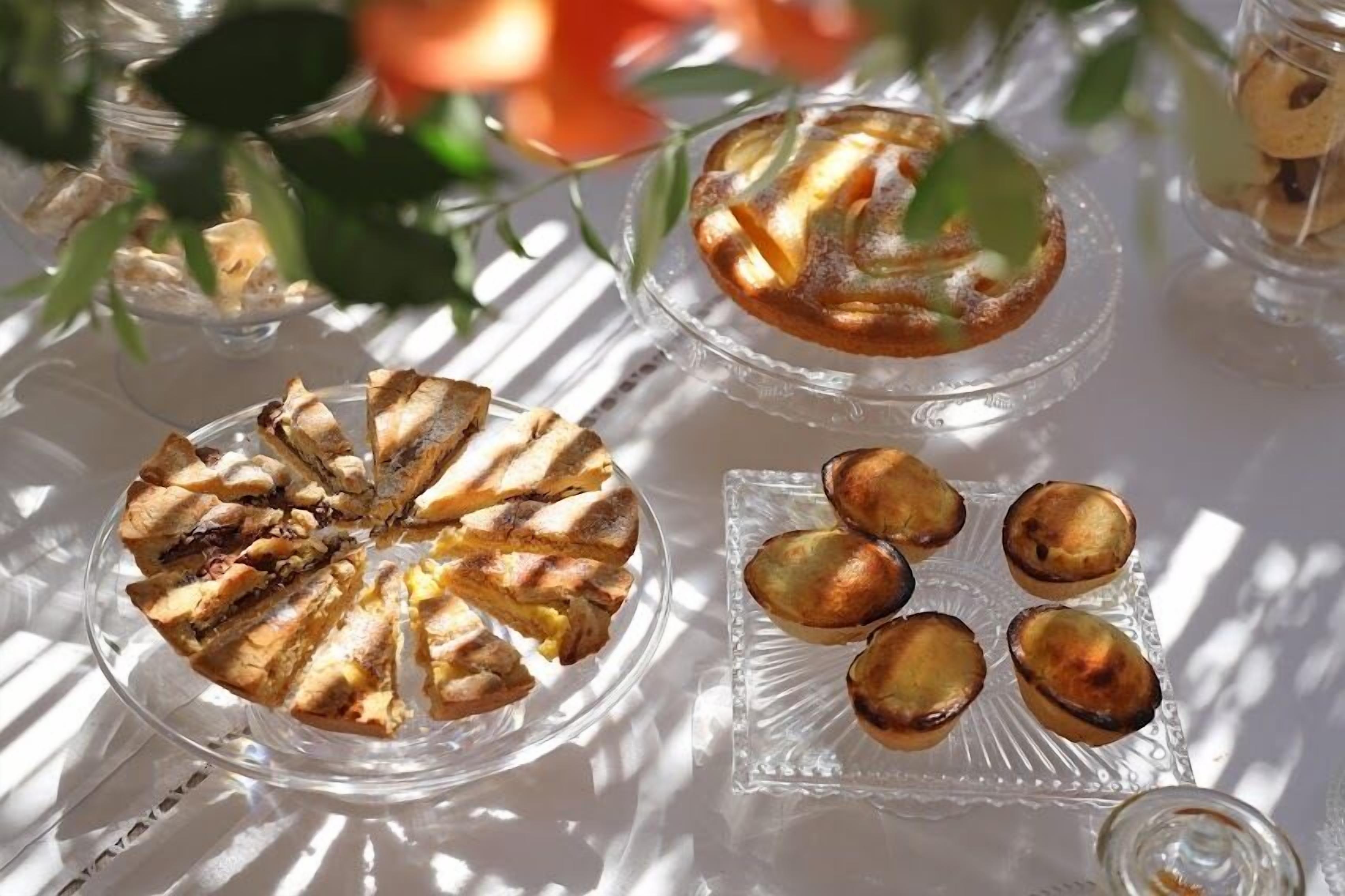 Una mesa con diversos pasteles en platos de vidrio.