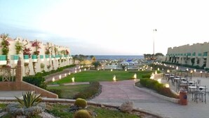 Un patio de hotel con asientos exteriores, un camino y vista al mar.