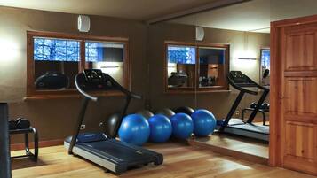 Ett gym inomhus med löpband, träningsbollar och en roddmaskin.