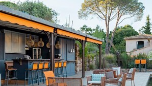 An outdoor seating area with wicker furniture and a pool. - Bastide de Ramatuelle (Ramatuelle)