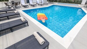 A swimming pool with lounge chairs and a floating mat. - GHL Hotel Neiva (Neiva)