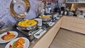 A buffet with various food items including waffles, pancakes, and a large pot of food. - GHL Hotel Neiva (Neiva)