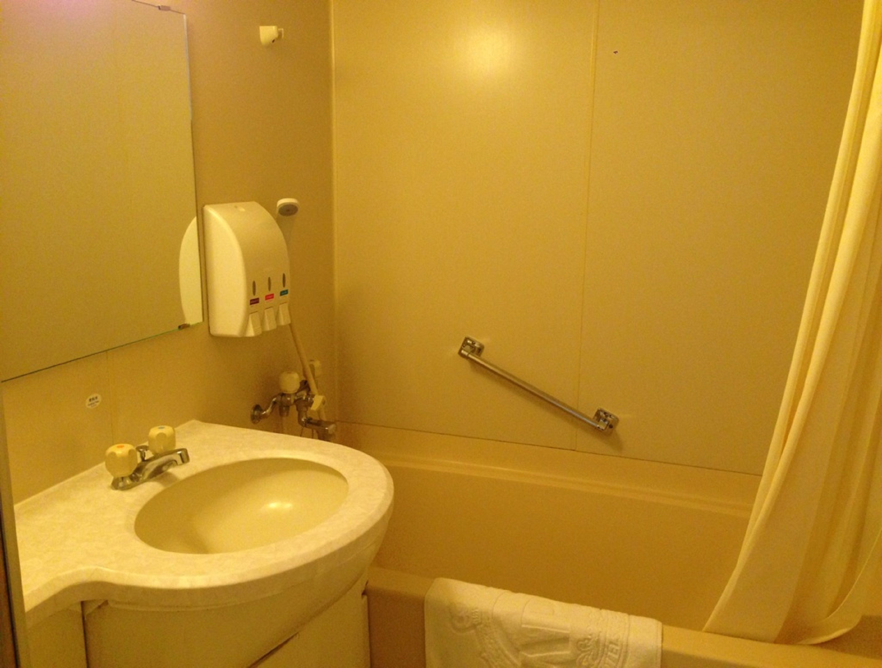 Un baño con lavamanos, inodoro y zona de ducha.