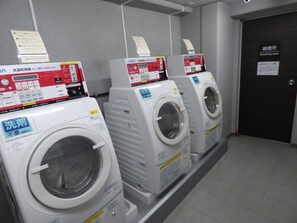 A row of front-loading washing machines in a commercial setting. - APA Hotel Takamatsu Kawaramachi (Takamatsu)