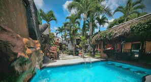 Alberca al aire libre y camastros 