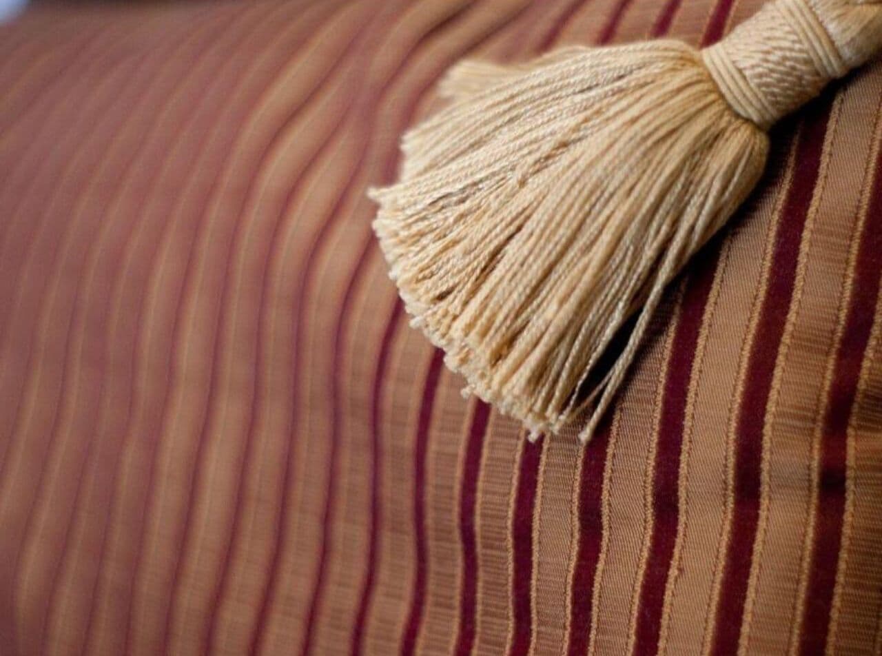 A close-up of a striped fabric with a tassel.