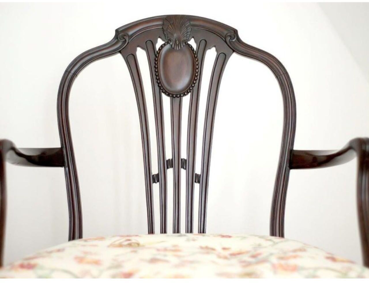 A wooden chair with a high back and a decorative central panel.