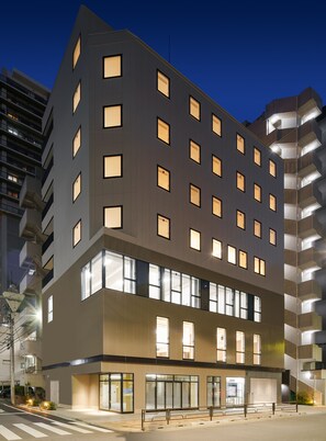 A modern multi-story hotel with a flat facade, numerous windows, and a ground-level entrance with a glass door. - Tokyo Ueno Youth Hostel (Tokyo)