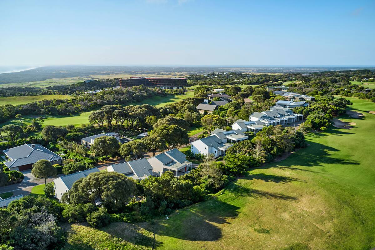 Zona residencial con casas alineadas, rodeada de vegetación y un campo de golf.