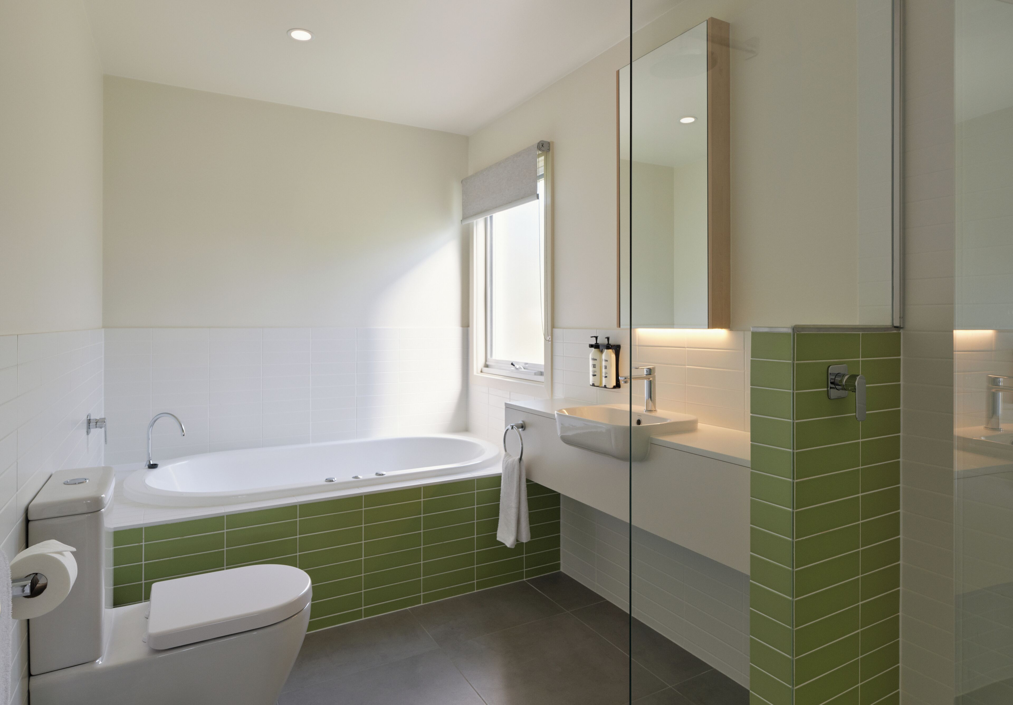A modern bathroom with a bathtub, toilet, and sink.