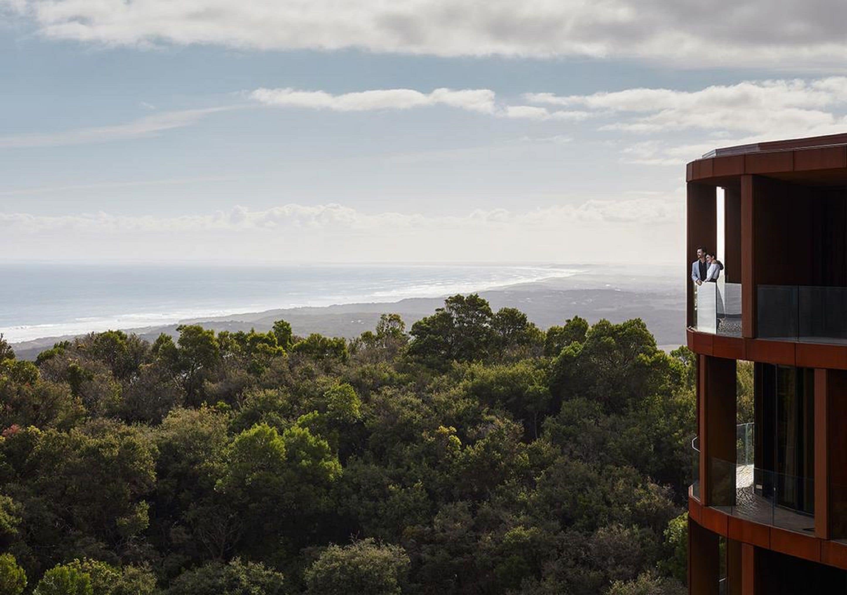 Ein modernes Gebäude mit einem Balkon mit Blick auf eine Küstenlandschaft.