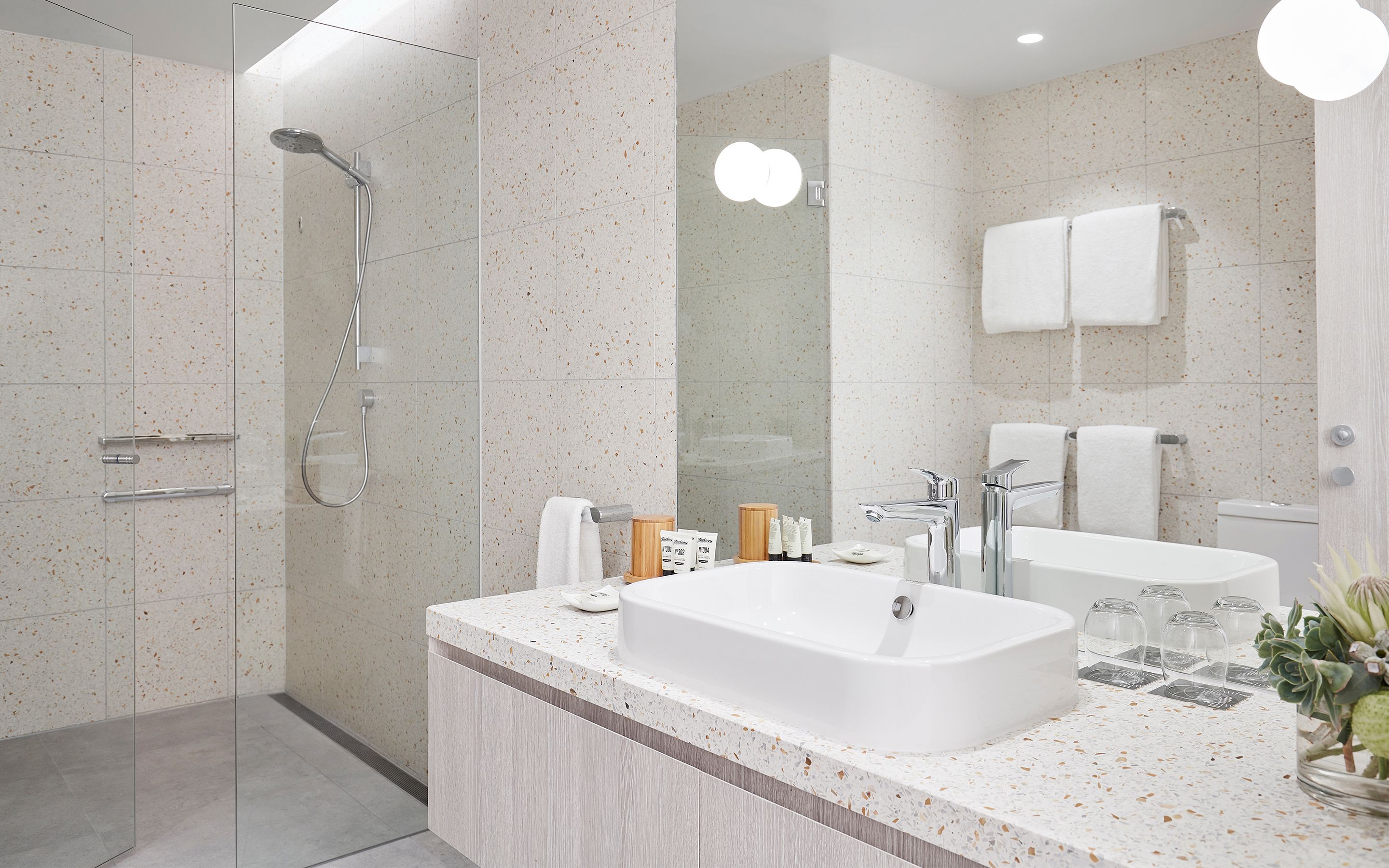 A modern bathroom with a freestanding bathtub, a glass-enclosed shower, and a large mirror.