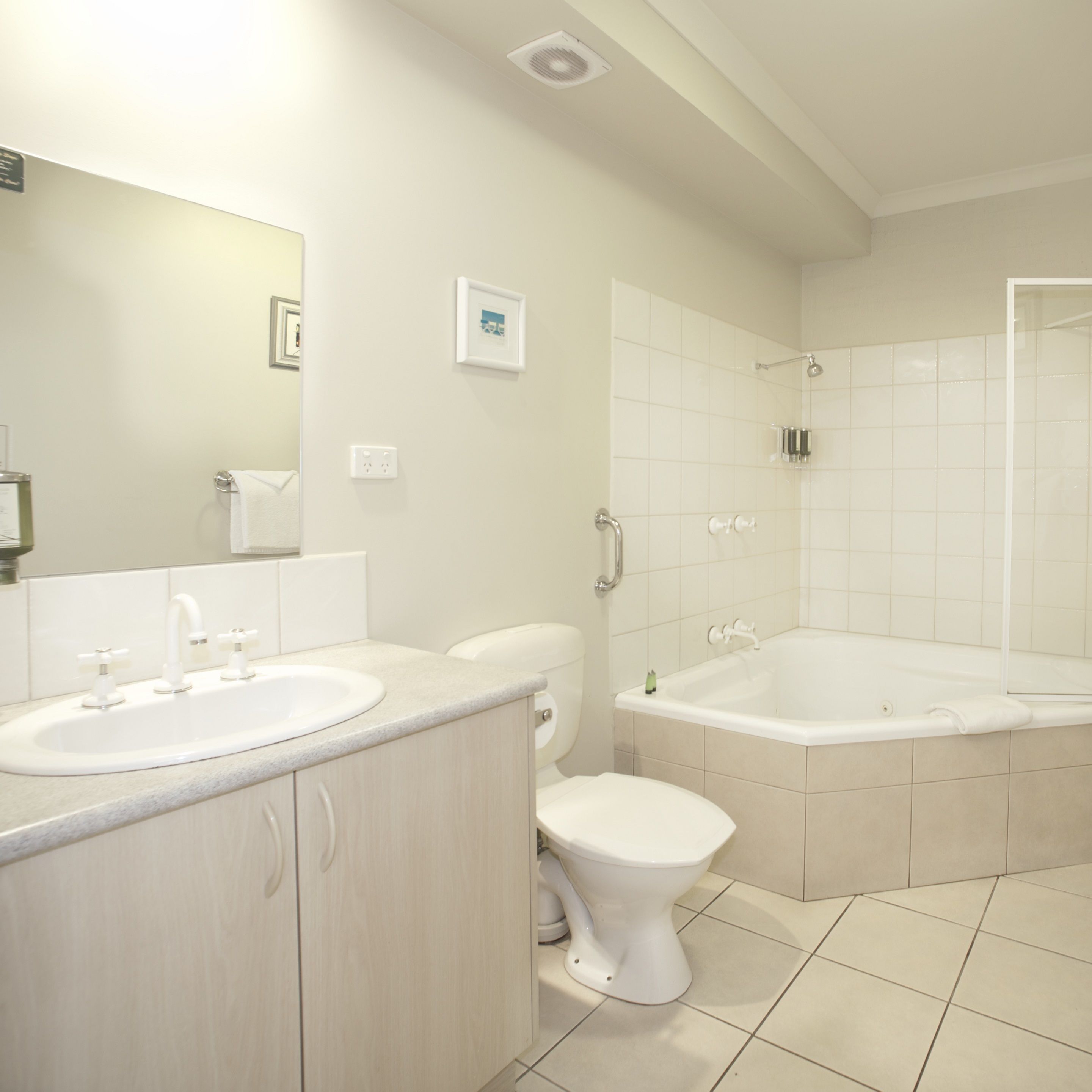 A modern bathroom with a sink, toilet, and bathtub.