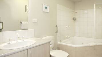 A modern bathroom with a sink, toilet, and bathtub.