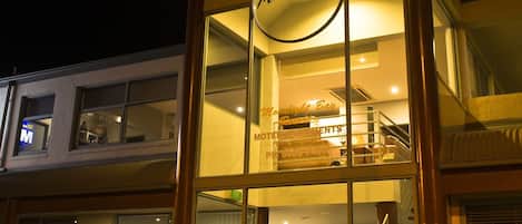 Un edificio de dos pisos con un letrero que dice "Moonlight Bar" en el nivel superior.